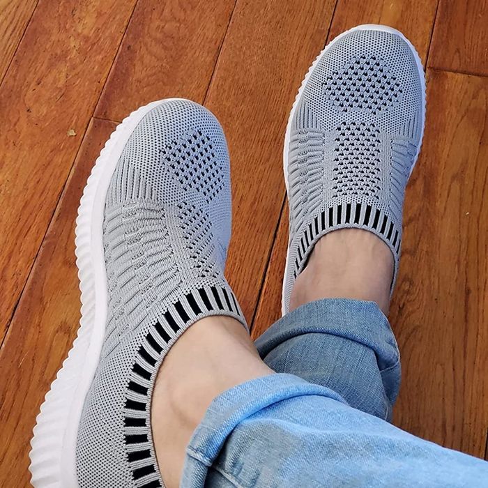 A reviewer wearing the grey knit sneakers