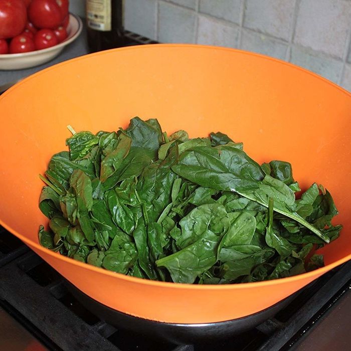 Spinach wilting in a pan; the Frywall keeps everything neatly contained