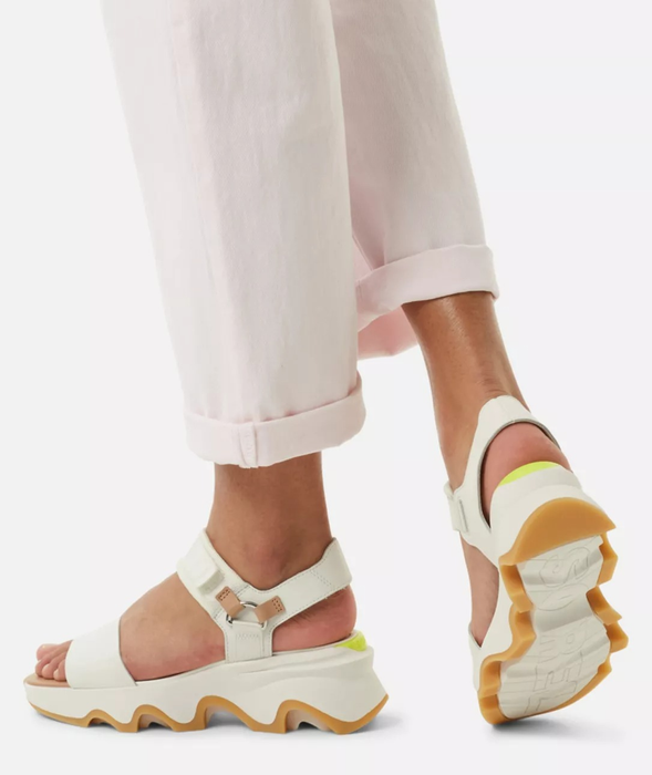 A model wearing sandals with chunky soles and straps