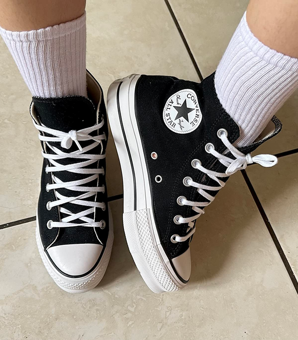 A reviewer wearing black Converse sneakers