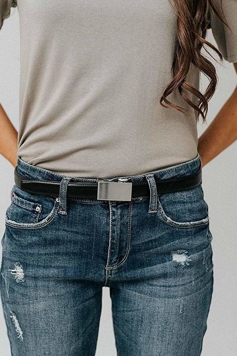 A model wears the black belt with a sleek rectangular metal buckle