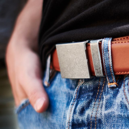 A model wears the brown belt with a stylish rectangular metal buckle