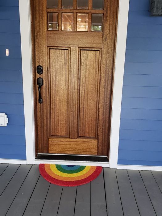 A rainbow doormat placed outside a home