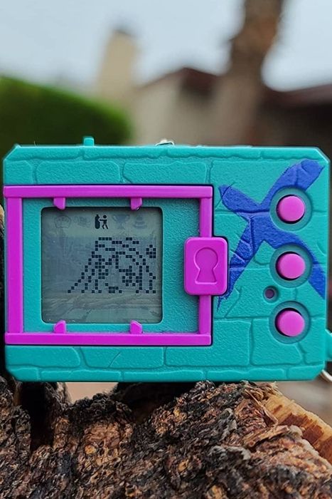 a digimon in teal and purple with a little person on the screen