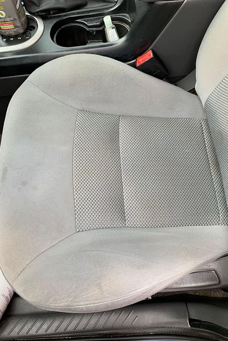 The same reviewer showing how the stains on their car seat have been removed.
