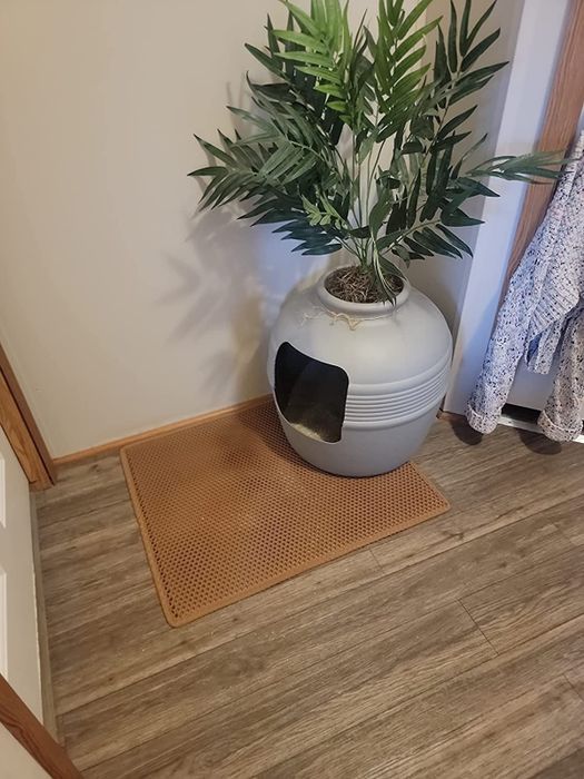 A reviewer's photo showing the litter mat placed under a litter box.
