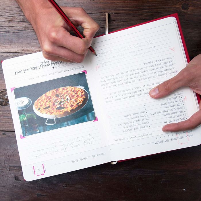 The inside of a recipe book with a photo of food taped to the page