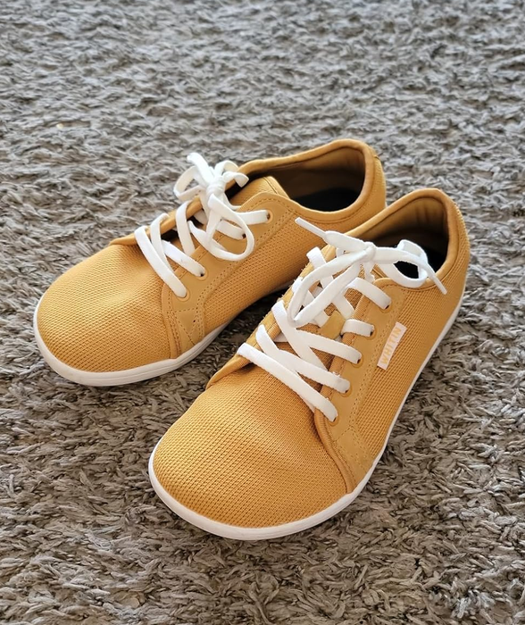 A pair of laid-back sneakers with white laces and a textured fabric
