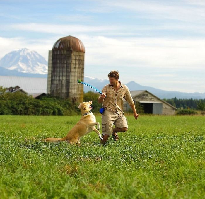 A model using the ball launcher to play with a large dog