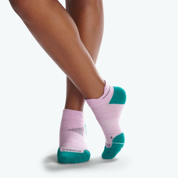 A model's feet in pink ankle socks with teal toes and heel