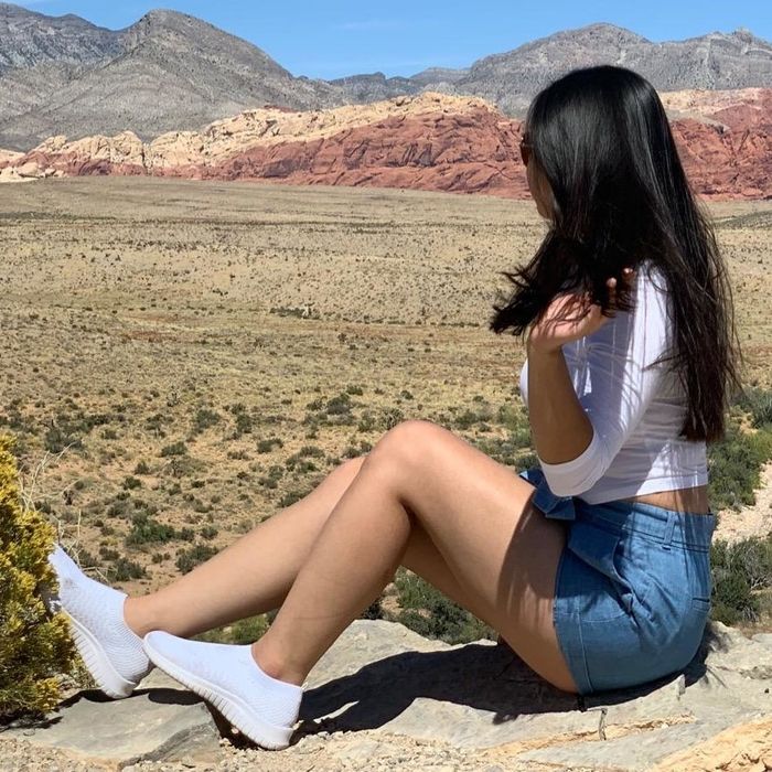 A reviewer wearing white sneakers