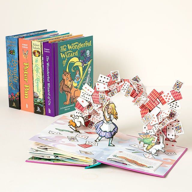 pop-up book featuring Alice being attacked by playing cards