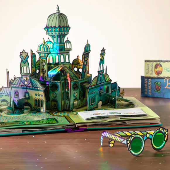 A pop-up page of the Emerald City displayed next to a pair of green paper glasses