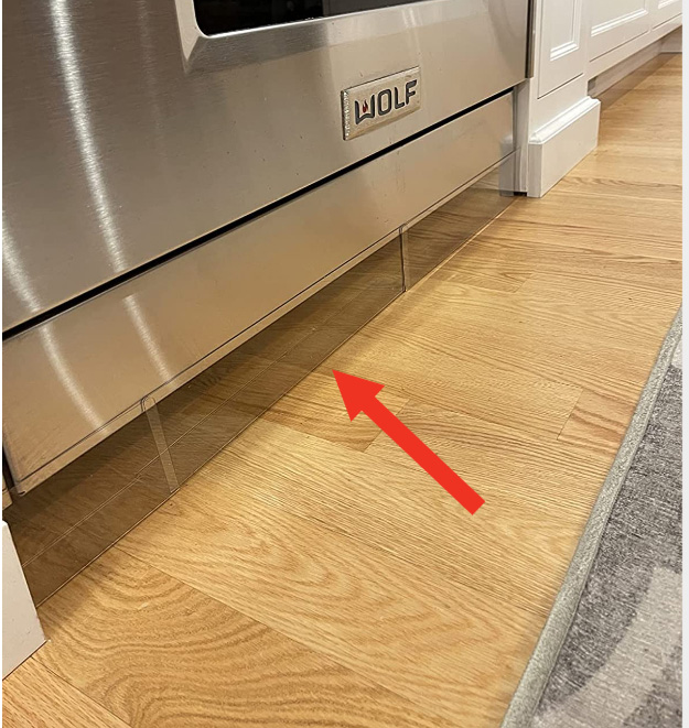 Clear plastic blockers placed under a stove to stop toys from rolling underneath