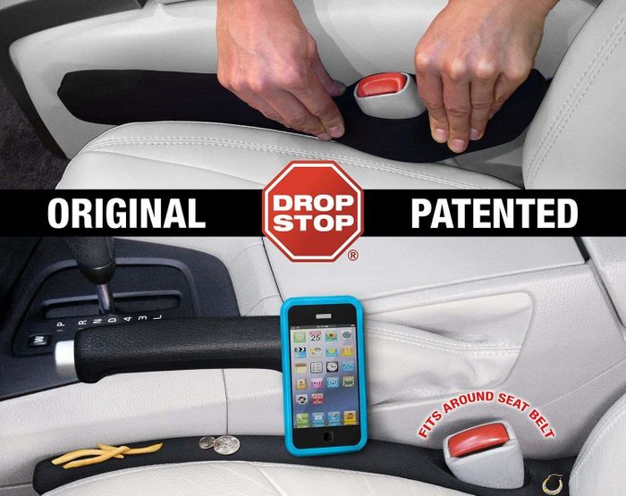 The black foam product, covered in fabric, sitting over a seatbelt holster, preventing a phone, fries, and coins from falling into the dreaded gap