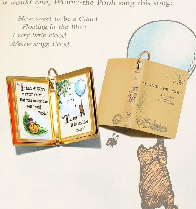 A gold book charm inspired by Winnie the Pooh with a tiny quote inside.