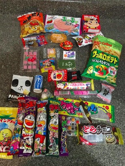 a variety of candy and snacks, all packaged in adorable designs, scattered on the floor