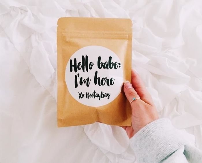 a hand holding an envelope that reads 