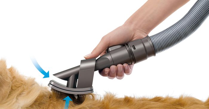 A close-up view of the grooming attachment, demonstrating how it fits onto the vacuum tube.