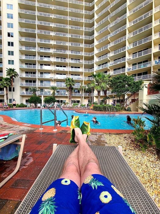 a reviewer sporting fish-shaped flip-flops by the pool