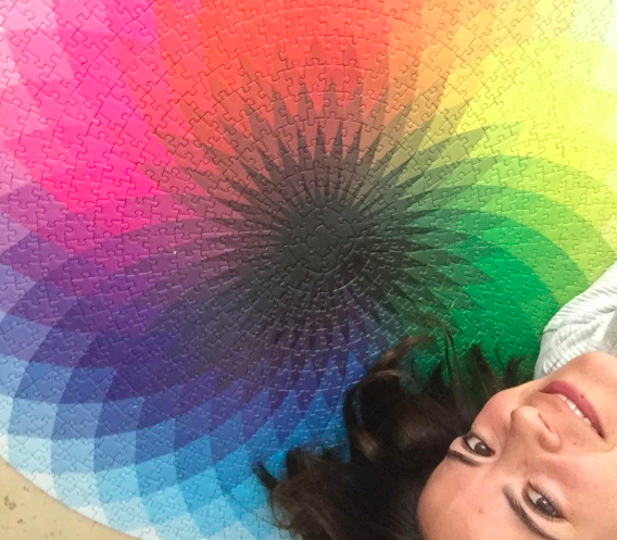 A reviewer standing next to the completed puzzle