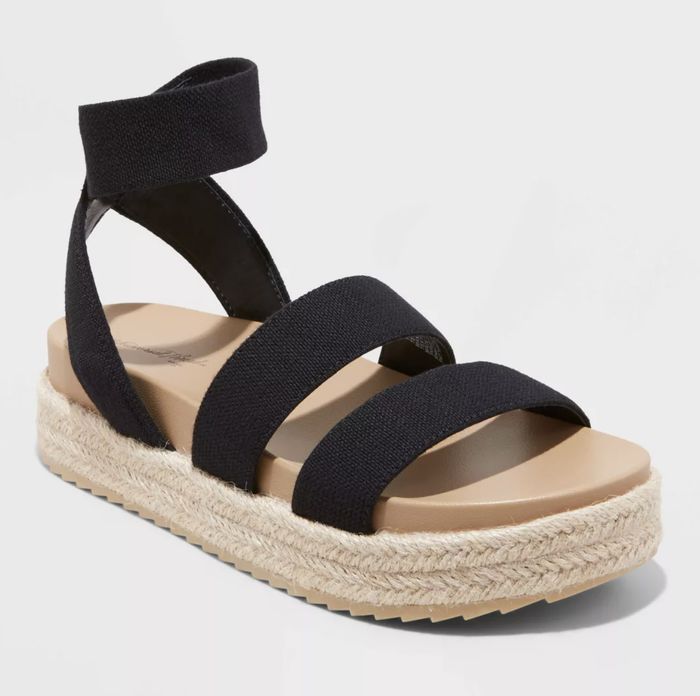 A black espadrille sandal featuring an ankle strap and a braided platform sole for a stylish summer look