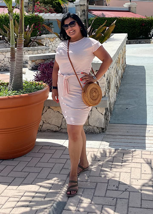 A reviewer wearing the pink and white version of the dress.