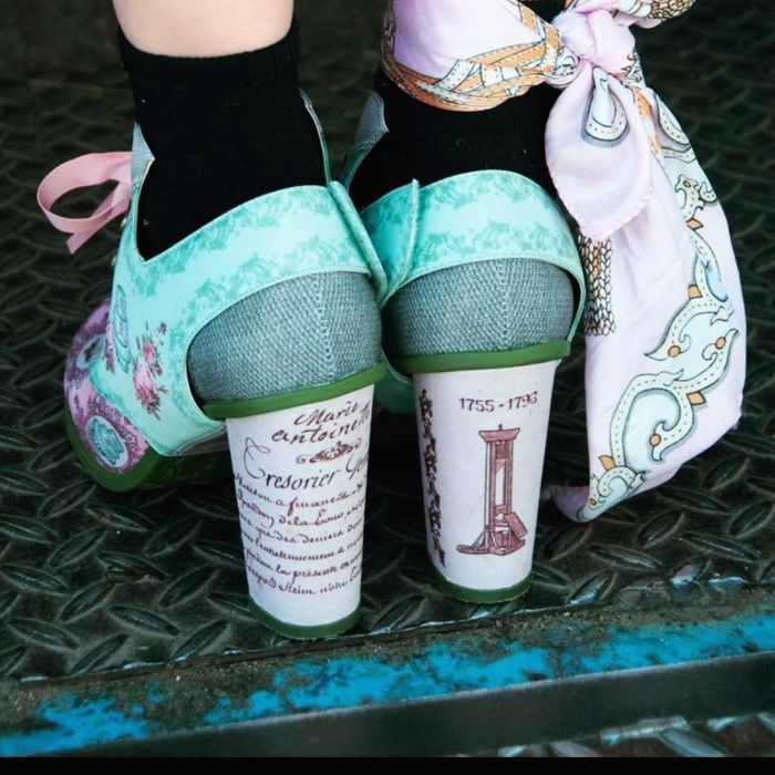 reviewer displaying the back of the shoes and the high heel