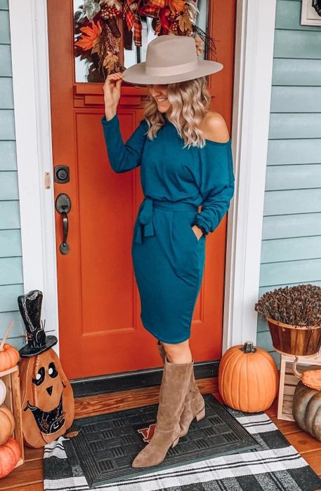A reviewer modeling the teal-colored dress