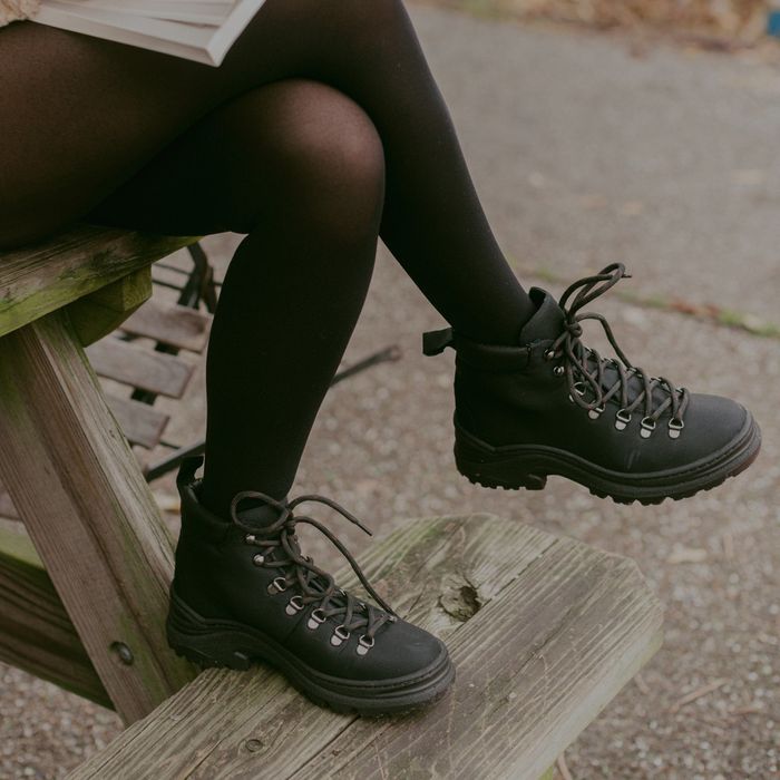 A model wearing black tights paired with the boots in all black.