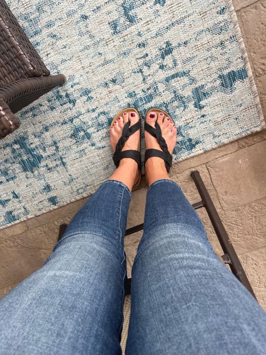 A customer styling the sandals in black for a chic look