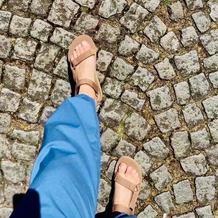A reviewer sporting a pair of classic brown sandals.