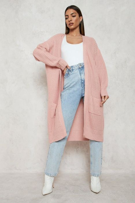 A model is showcasing the pink cardigan in this stylish look.