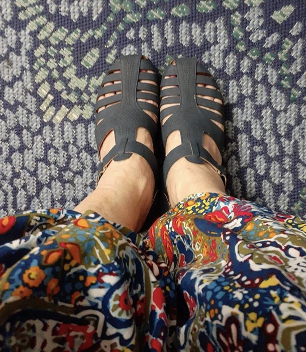 A reviewer wearing the sandals in a chic navy shade