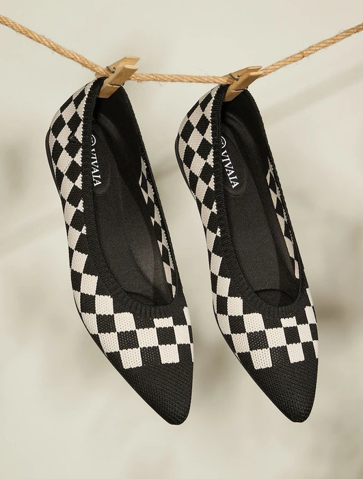 A pair of knit pointed toe flats featuring a black and white checkerboard pattern.