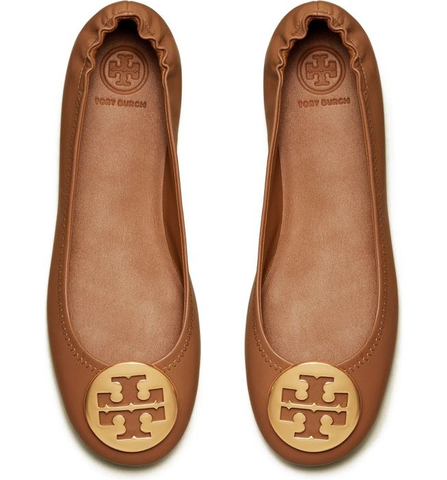 Overhead view of tan flats featuring gold logo medallions