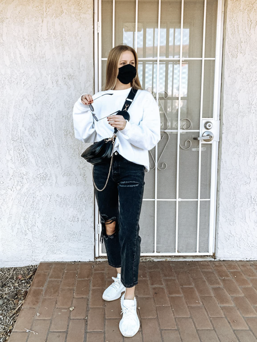 A reviewer showcasing the black crossbody bag