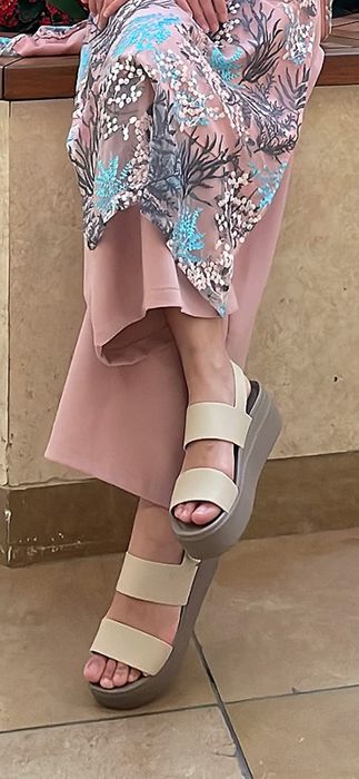 Reviewer wearing white Crocs platform shoes paired with a skirt.
