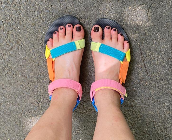 A reviewer's feet in multicolored sandals