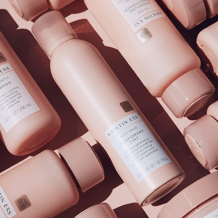 Bottles of the product arranged on a pink backdrop