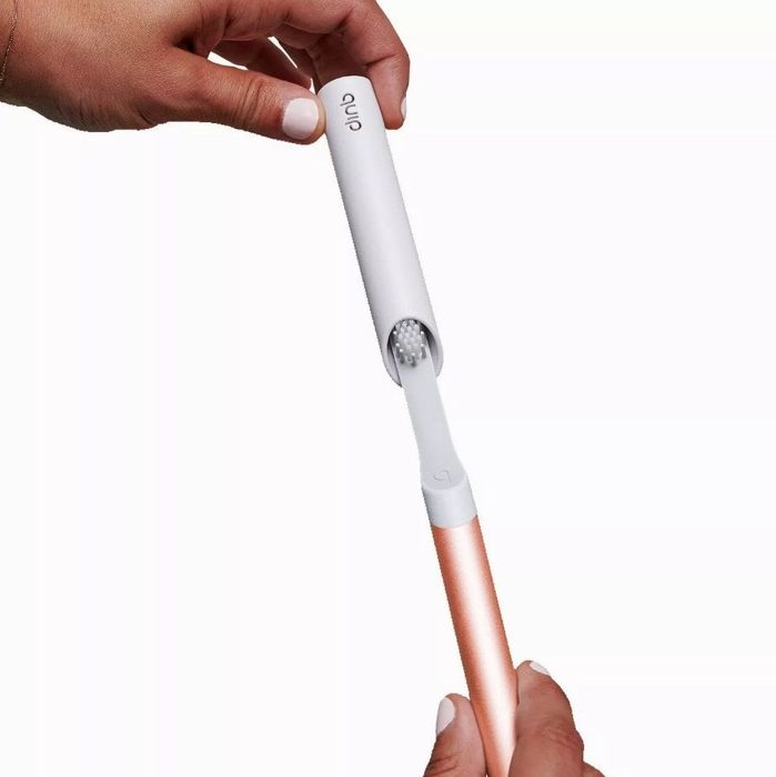 A model placing the travel cap safety cover onto a Quip electric toothbrush