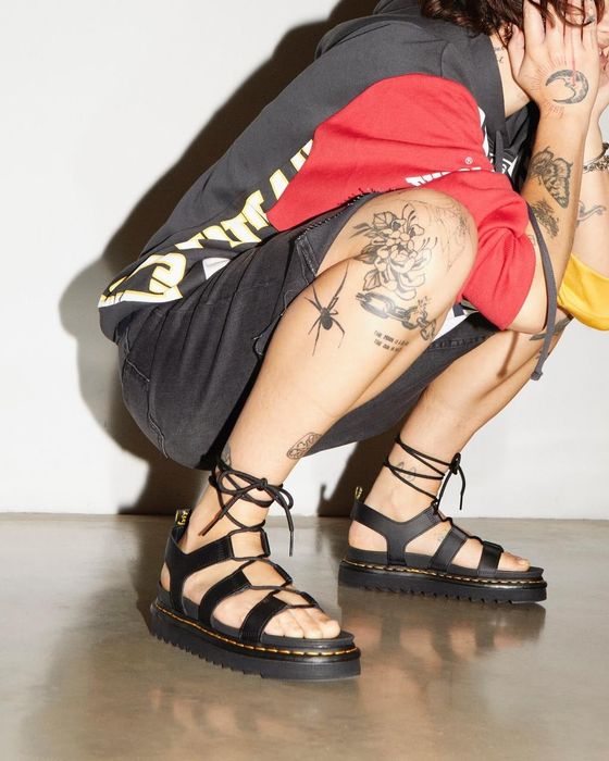 A close-up of another model wearing the black gladiator sandals.