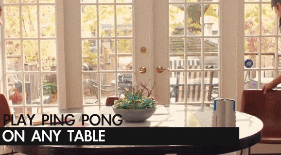A gif of a family of three setting up the table and having fun playing in their dining room.
