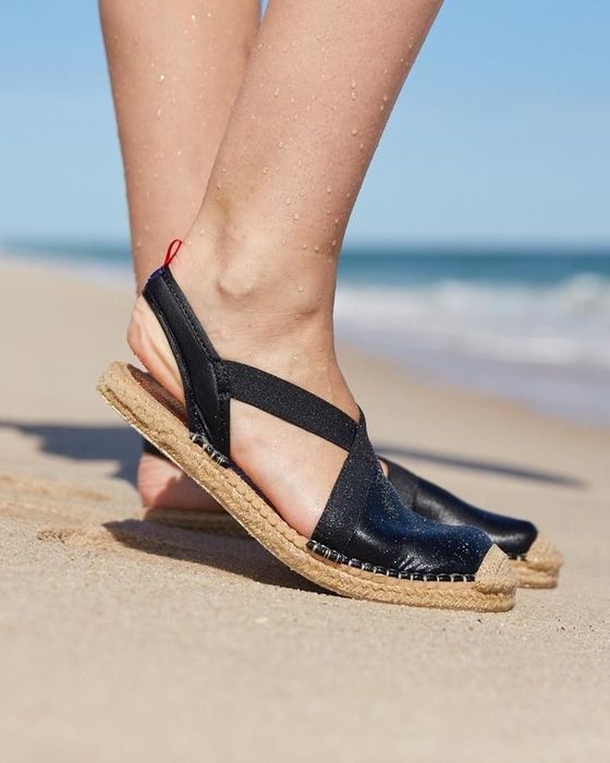 Model wearing waterproof espadrilles with a slingback design while enjoying a day at the beach