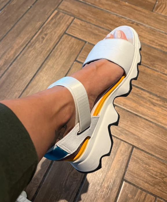 reviewer showcasing the white sandal from the side