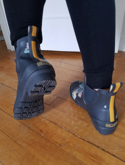 reviewer showcasing the tread pattern on the bottom of the boots