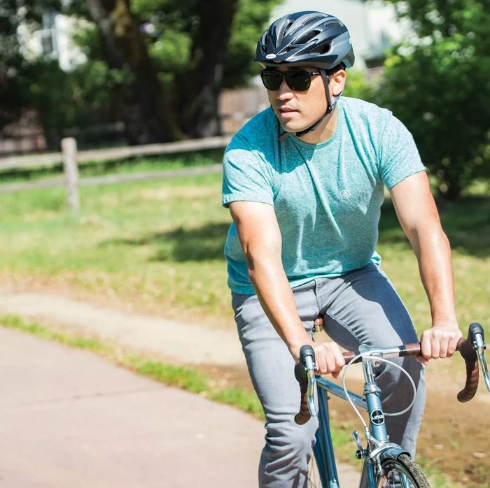 A model riding a bike while wearing the adjustable helmet for a secure fit.