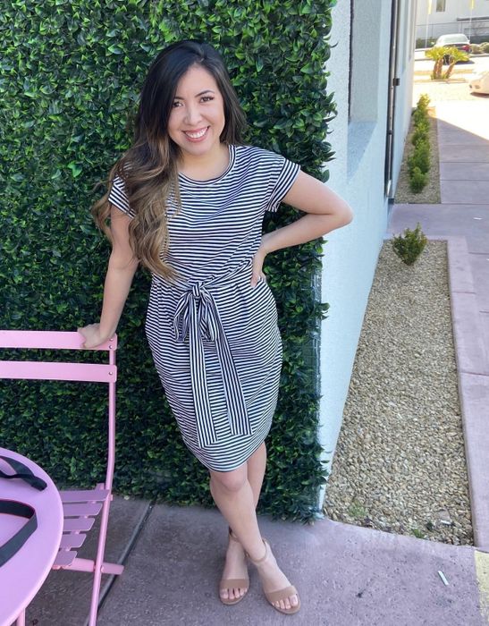 A reviewer rocking the navy dress with white stripes and heeled sandals.