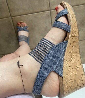 Close-up of a reviewer’s foot wearing the blue sandals.