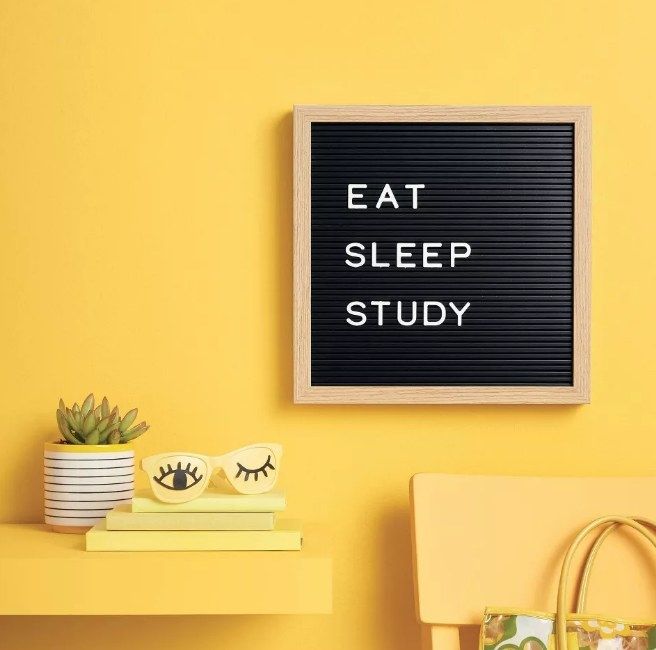 A black letterboard that displays 'eat, sleep, study' mounted on a wall